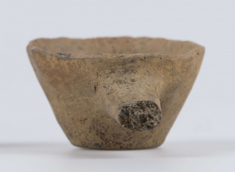 1702/A/ML - dno płaskie, ścianki proste, wylew zawinięty do wewnątrz; krawędź zaokrąglona; pod krawędzią umieszczono trzymadełko prostopadłe do ścianki, o przekroju owalnym, ułamane