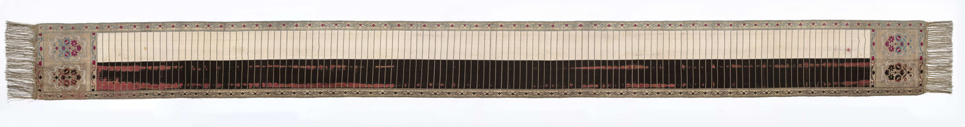 Pas kontuszowy 4-stronny
Ornament:
głowy - dwa krzaczki kwiatowe otoczone medalionami z wijącej się wstęgi
środek ( wciąż)- poprzeczne gładkie pólka
obwódki - z motywem kostki i rombów
obrzeżenia pionowe z motywem podwójnej przeplatającej się wici roślinnej, poziome - z motywem wijacej sie wstążki z kwiatami
Kolor:
pr. - tło głów i obrzeżeń srebrne, ornament brązowy z błękitem i amarantem, pólka w połowie brązowe (czarne ?), w połowie kremowe
l. - tło połowy głów i obrzeżeń błękitne oraz  w połowie pólek amarantowe, druga połowa głów i obrzeżeń brązowa oraz pólek - amarantowa
W narożnikach sygnatura wytkana 