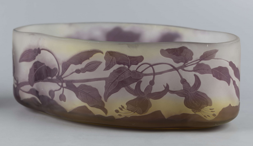 S/CS/1385/ML - Żardiniera ze szkła grubościennego, bezbarwnego, matowanego, podbarwianego żółtym i liliowym pudrem; na niskiej spiczasto-owalnej podstawie korpus o ściankach pionowo sfalowanych, u dołu lekko zaokrąglony, górna krawędź ścięta. Korpus pokryty warstwą liliową, w niej trawiony wzór roslinny: gałązka fuksji z kwiatami, przy dnie dookoła  pasmo liliowe o nieregularnym wykroju.
 