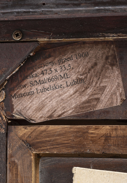 Obraz przedstawia portret męski - postać ujęta w popiersiu z głową wspartą na prawej dłoni, przedstawiona en face. Mężczyzna ubrany jest w białą koszulę, ciemny krawat i ciemny garnitur. Twarz szczupła, pociągła, cera śniada, oczy niebieskie, brwi zarysowane wydatnym łukiem, nos prosty, usta pełne, nad nimi cienkie, krótkie wąsy. Włosy czarne delikatnie falowane nad czołem. Tło obrazu w kolorystyce szarości i zieleni.