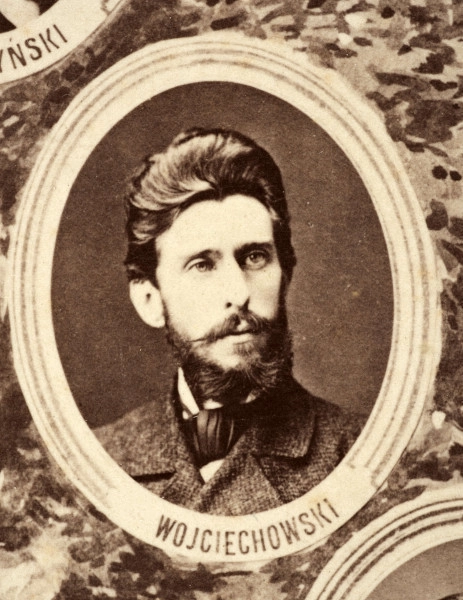Fotografie w odcieniu sepii umieszczone na tle drzew i roślin, w centralnym miejscu postać kobiety ze sztandarem i aniołkami, wkomponowane widoki budowanej stacji, mostu kolejowego i lokomotywy. Największe zdjęcie w górnej, środkowej części bez podpisu, prawdopodobnie inż. głównej kolei nadwiślańskiej Tadeusz Chrzanowski lub jego następca Walery Titkow. Wśród podobizn pracownicy Biura Głównego Inżyniera: inż. Włodzimierz Stanisławski - pomocnik głównego inżyniera; inż. Feliks Kucharzewski -  pomocnik naczelnika biura; Feliks Kamocki - naczelnik kancelarii; Witold Lanci - naczelnik Wydz. Architektury; dr Wacław Lasocki- służba zdrowia; Władysław Radwan - sprawy zakupu gruntów; inż. Stanisław hr Scipio - projektant mostów kolejowych i jego współpracownicy: inż. Stefan Zieliński, inż. Maurycy Machalski, inż. Feliks Kucharzewski. Fotografia w passe - partout, za szkłem, oprawiona w drewnianą, profilowaną ramę.