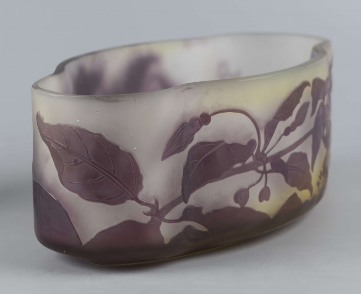 S/CS/1385/ML - Żardiniera ze szkła grubościennego, bezbarwnego, matowanego, podbarwianego żółtym i liliowym pudrem; na niskiej spiczasto-owalnej podstawie korpus o ściankach pionowo sfalowanych, u dołu lekko zaokrąglony, górna krawędź ścięta. Korpus pokryty warstwą liliową, w niej trawiony wzór roslinny: gałązka fuksji z kwiatami, przy dnie dookoła  pasmo liliowe o nieregularnym wykroju.
 