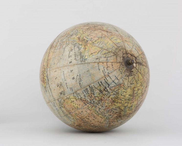 Globus fizyczno-polityczny Ziemi w skali 1:80 mln, litografia kolorowa; 12 segmentów, z polską nomenklaturą; południk zerowy biegnie przez Greenwich. Kula tekturowa, postument drewniany toczony, ramię metalowe, bez południka. Na globusie obie Ameryki, Azję i Australię otoczono czerwoną wstęgą, Afrykę - niebieską, Europa - zielono-żółtą. 