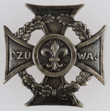 ML/MART/373 - Krzyż harcerski 4-ramienny wykonany z metalu, na środku lilijka harcerska, krzyż otaczają liście wawrzynu; napis na bocznych ramionach 