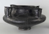 598/A/ML - naczynie kultowe (kernos) kultury pomorskiej; 
wymiary dodatkowe: 25,0 cm - średnica centralnego wylewu
opis: naczynie wazowate o czarnej, błyszczącej powierzchni, którego brzusiec został ozdobiony ornamentem złożonym z linii rytych oraz nakłuć; wokół głównego otworu posiada cztery symetrycznie rozmieszczone kielichy-rytony, które mają nieco wydęte ścianki boczne i kielichowato rozchylone na zewnątrz krawędzie otworów; rytony łączą się z głównym otworem kanalikami; 