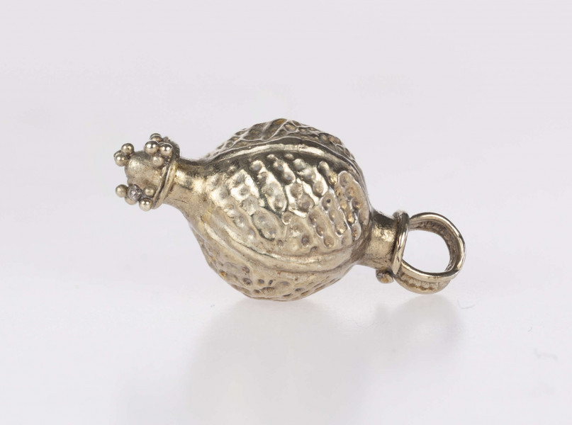 Wisiorek kulisty, typ Ia (wg. klasyfikacji A. v. Müllera). Korpus zdobiony czterema pionowymi żeberkami i wybijanymi punkcikami, wypełniającymi liniami w układzie skośnym pola pomiędzy nimi. Wieszadełko składające sie z szyjki przylegającej bezpośrednio do kuli, wieńczącego ją pierścienia i uszka taśmy z pogrubionym brzegiem z polem między nimi wypełnionym granulacją. Na dole wisiorka znajduje się element w postaci tulejki z przylutowanym stożkiem umieszczonym na profilowanej płyce, której narożniki, jak i szczyt stożka, zdobią triady granulek. Wisiorek prawdopodobnie był importem z terenów kultury wielbarskiej.
Wymiary dodatkowe: 2,5 mm (śr. szyjki wieszadełka); 2,5 mm (wys. szyjki wieszadełka); 4,0 mm (śr. pierścienia wieszadełka); 2,0 mm (szer. uszka); 2,0 mm (śr. tulejki); 1,5 mm (wys. stożka)