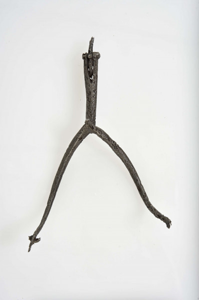 Ostroga żelazna w kształcie wideł z półkoliście wygiętymi ramionami zakaończonymi gwiazdkami; kolec również zakończony gwiazdką umocowaną przez włożenie jej w rozszczepiony kolec i przewleczono nitem