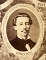 Fotografie w odcieniu sepii umieszczone na tle drzew i roślin, w centralnym miejscu postać kobiety ze sztandarem i aniołkami, wkomponowane widoki budowanej stacji, mostu kolejowego i lokomotywy. Największe zdjęcie w górnej, środkowej części bez podpisu, prawdopodobnie inż. głównej kolei nadwiślańskiej Tadeusz Chrzanowski lub jego następca Walery Titkow. Wśród podobizn pracownicy Biura Głównego Inżyniera: inż. Włodzimierz Stanisławski - pomocnik głównego inżyniera; inż. Feliks Kucharzewski -  pomocnik naczelnika biura; Feliks Kamocki - naczelnik kancelarii; Witold Lanci - naczelnik Wydz. Architektury; dr Wacław Lasocki- służba zdrowia; Władysław Radwan - sprawy zakupu gruntów; inż. Stanisław hr Scipio - projektant mostów kolejowych i jego współpracownicy: inż. Stefan Zieliński, inż. Maurycy Machalski, inż. Feliks Kucharzewski. Fotografia w passe - partout, za szkłem, oprawiona w drewnianą, profilowaną ramę.