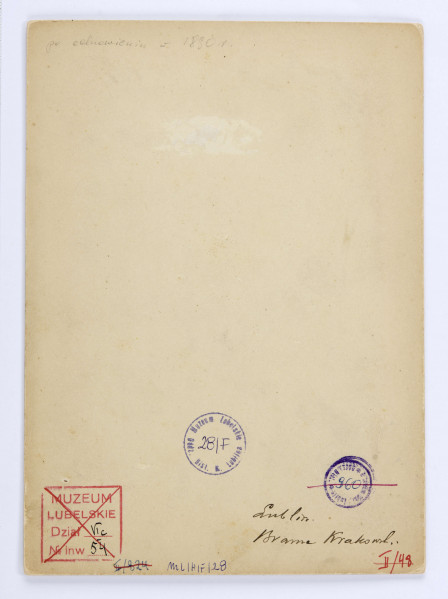 Brama Krakowska otynkowana, z balustradą żelazna dookoła wieży na wysokosci balkonu. Pod zegarem podwieszona informacja o temperaturze powietrza: 