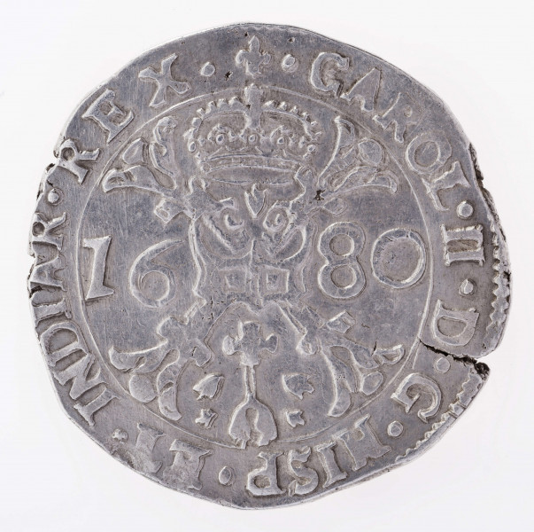 Aw. W tondzie ujętym pojedynczym otokiem liniowym ukoronowany krzyż kwiatowy ze zwieszającą się od niego odznaką orderu Złotego Runa. Krzyż rozdziela datę; umieszczoną na osi poziomej: 16 – 80. Legenda dookolna spięta u góry znakiem menniczym:
.CAROL.II.D.G.HISP.ET.INDIAR.REX.
Przy obrzeżu fragment otoku nieliniowego.

Rw. W tondzie ujętym pojedynczym otokiem liniowym ukoronowana, wielodzielna tarcza herbowa ujęta łańcuchem z odznaką orderu Złotego Runa. Legenda dookolna rozdzielona u góry koroną:
.ARCHID.AVST.DVX.BVRG.CO.FLAN.Z
Przy obrzeżu fragment otoku nieliniowego.
