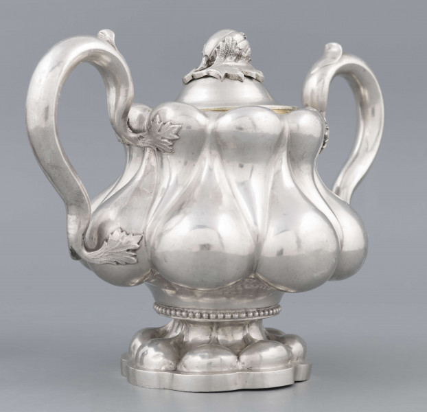 S/Mt/392/ML - Stopa ośmiolistna z ośmioma wydatnymi puklami; trzon krótki zdobiony rzedem perełek; korpus gruszkowaty pokryty dwoma rzędami pukli w formie kropel - większe na dole, mniejsze u góry; po bokach dwa ucha w formie litery 