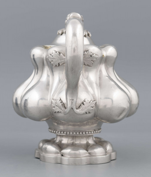 S/Mt/392/ML - Stopa ośmiolistna z ośmioma wydatnymi puklami; trzon krótki zdobiony rzedem perełek; korpus gruszkowaty pokryty dwoma rzędami pukli w formie kropel - większe na dole, mniejsze u góry; po bokach dwa ucha w formie litery 