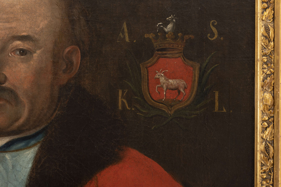 Portret sarmacki przedstawiający szlachcica, starszego mężczyznę w ujęciu do bioder, zwróconego 3/4 w prawo.Kontrast pomiędzy żywą barwą postaci a ciemnym tłem. Portretowany lewą ręką ujmuje kościaną rękojeść karabeli, prawą ma uniesiona na tę samą wysokość. Twarz charakterystyczna, o zdecydowanych rysach, ze zmarszczkami, łysiną, z wianuszkiem blond włosów wokół głowy. Brązowe oczy, o przenikliwym spojrzeniu, skierowane na widza, wydatny, orli nos, sumiaste, obfite, jasne wąsy. Mężczyzna ubrany w karmazynowy kontusz, podbity ciemnobrązowym futrem, z rzędem złotych guzów. Pod kontuszem bladoniebieski żupan z rzędem koralowych guzików, pod szyją z widocznym białym stojącym kołnierzykiem koszuli, spiętym złotą ozdobą. Żupan w pasie  przewiązany złotolitym, orientalnym, barwnym pasem kontuszowym. Na małym palcu lewej dłoni duży pierścień z błękitnym oszlifowanym kamieniem. Tło ciemne,neutralne. W lewym, górnym rogu tarcza herbowa z herbem Junosza i 4 złote litery: 