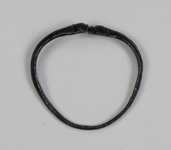 824/A/ML/1 - Żelazna bransoleta ze stylizowanymi wężowymi główkami. W części środkowej przekrój trapezowaty, przy główkach trójkątny.