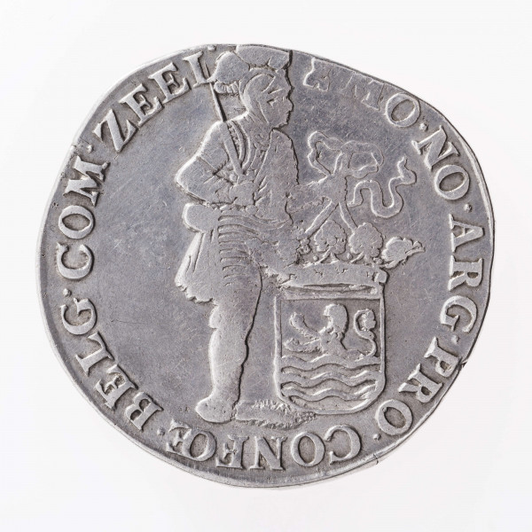 Aw. Postać rycerza w zbroi, głową zwrócona w prawo, z przyłbicą  z podniesioną zasłoną. Rycerz w prawej dłoni trzyma miecz ostrzem skierowany do góry, a w lewej na wstędze tarczę z herbem prowincji Zelandia. Legenda dookolna rozdzielona na górze wizerunkiem, poprzedzona znakiem menniczym:
MO.NO.ARG.PRO.CONFOE.BELG.COM.ZEEL
Dwie ostatnie litery w członie CONFOE oddane w formie ligatury. 

Rw. Ukoronowana tarcza z herbem Republiki Zjednoczonych Prowincji dzieląca datę 16 – 98, umieszczoną na osi poziomej. Legenda dookolna:
CON.CORDIA.RES.PARVAE.CRESCUUNT
Ostatnie dwie litery w wyrazie PARVAE oddane w formie ligatury. 