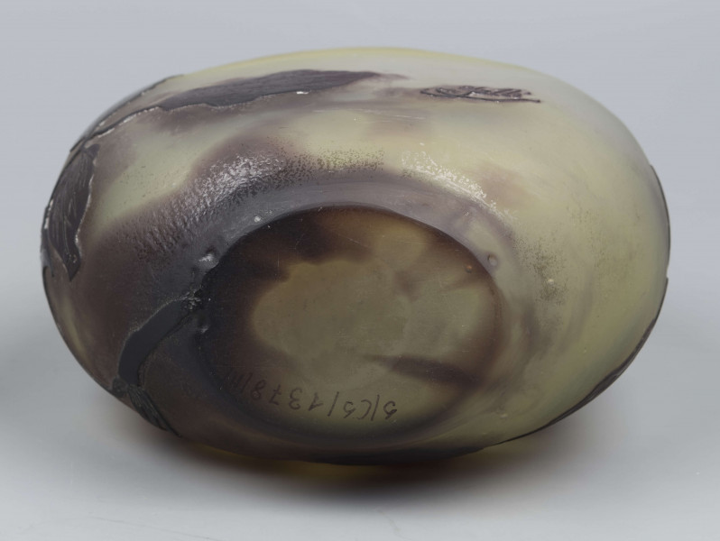 S/CS/1378/ML - Wazon w formie kuli pionowo spłąszczonej z krótką szyją i owalnym wylewem, szeroko wywiniętym, z płasko sciętym brzegiem; ze szkła bezbarwnego, matowionego, przy dnie i przy szyi barwionego na kolor żółty i fioletowobrunatny. Na powierzchni plastyczny wzór swobodnie rzuconej gałązki klematisu z kwiatami w kolorze fioletowobrunatnym.
 