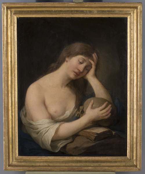 S/Mal/797/ML - Święta przedstawiona jest jako młoda kobieta. Siedzi przy stole, zwrócona w 3/4 prawą stroną do widza. Ukazana jest w ujęciu do pasa, pochyloną głowę opiera na lewej ręcę, wspartej łokciem na stole. Prawą dłonią obejmuje czaszkę, ułożoną na otwartej księdze (położonej na stole). Wzrok ma spuszczony, spogląda na czaszkę. Twarz delikatna, prosty nos, pełne usta. Włosy długie, opadające na plecy. Karnacja twarzy i ciała - ciepła, jasna. Maria ubrana jest w białą koszulę, odsłaniającą prawą pierś i ramię oraz niebieski szal. Tło ciemne.