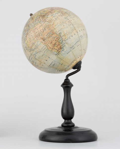 Globus fizyczno-polityczny Ziemi w skali 1:80 mln, litografia kolorowa; 12 segmentów, z polską nomenklaturą; południk zerowy biegnie przez Greenwich. Kula tekturowa, postument drewniany toczony, ramię metalowe, bez południka. Na globusie obie Ameryki, Azję i Australię otoczono czerwoną wstęgą, Afrykę - niebieską, Europa - zielono-żółtą. 