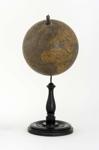 Globus bez tytułu, roku wydania i granic państwowych. Brak hipsometrii, powierzchnia kontynentów jest bladożółta za wyjątkiem białej Antarktydy. Na lądach naniesiono rzeki, pustynie i jeziora zaznaczono szrafurą. Największe góry oznaczono metodą kreskową (za pomocą 