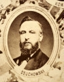 Fotografie w odcieniu sepii umieszczone na tle drzew i roślin, w centralnym miejscu postać kobiety ze sztandarem i aniołkami, wkomponowane widoki budowanej stacji, mostu kolejowego i lokomotywy. Największe zdjęcie w górnej, środkowej części bez podpisu, prawdopodobnie inż. głównej kolei nadwiślańskiej Tadeusz Chrzanowski lub jego następca Walery Titkow. Wśród podobizn pracownicy Biura Głównego Inżyniera: inż. Włodzimierz Stanisławski - pomocnik głównego inżyniera; inż. Feliks Kucharzewski -  pomocnik naczelnika biura; Feliks Kamocki - naczelnik kancelarii; Witold Lanci - naczelnik Wydz. Architektury; dr Wacław Lasocki- służba zdrowia; Władysław Radwan - sprawy zakupu gruntów; inż. Stanisław hr Scipio - projektant mostów kolejowych i jego współpracownicy: inż. Stefan Zieliński, inż. Maurycy Machalski, inż. Feliks Kucharzewski. Fotografia w passe - partout, za szkłem, oprawiona w drewnianą, profilowaną ramę.