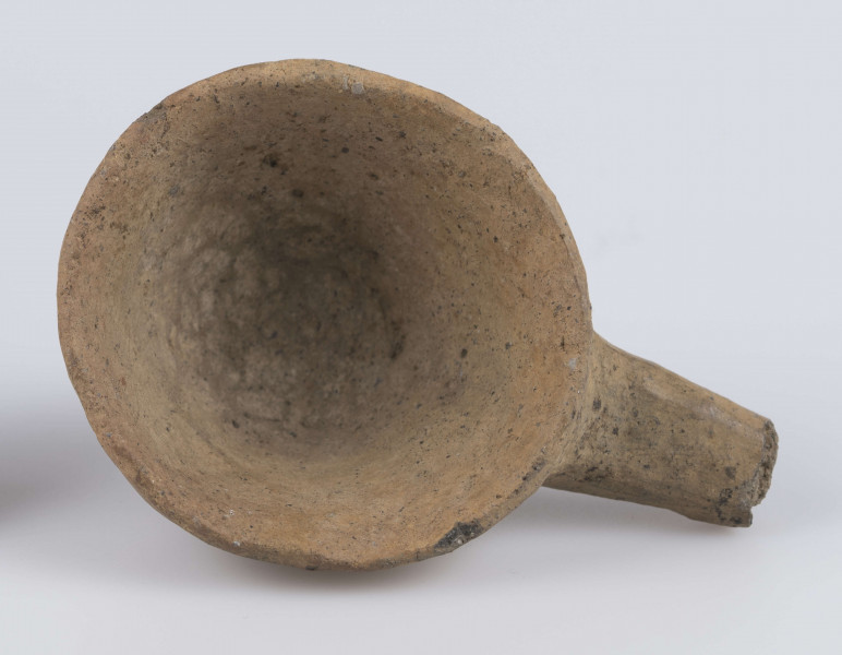 1702/A/ML - dno płaskie, ścianki proste, wylew zawinięty do wewnątrz; krawędź zaokrąglona; pod krawędzią umieszczono trzymadełko prostopadłe do ścianki, o przekroju owalnym, ułamane