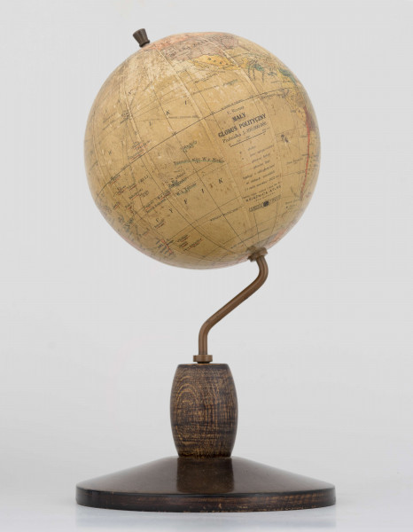 Mały polityczny globus Ziemi z polską nomenklaturą w skali 1:100 mln. Litografia kolorowa; 12 segmentów i 2 koła. Globus zamontowany na ramieniu drucianym, model 