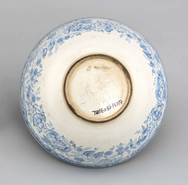 Miseczka półkulista, na niskiej, okrągłej stopce. Zdobiona od strony zewnetrznej i wewnętrznej nadrukiem w kolorze błękitnym z wzorem wolut i ukwieconych gałązek róży i goździków. W lustrze scena w kolorze czarnym przedstawiająca młodą dziewczynę w ogrodzie z elementami 