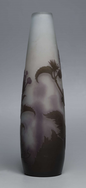 S/CS/1620/ML - Wazon o kształcie wrzecionowatym ze szkła grubościennego, matowego, bezbarwnego,  podbarwionego od dołu fioletem, od góry błękitem. Powlekany warstwą liliową i brązowooliwkową; w niej trawiona i polerowana dekoracja roślinna: swobodnie rozmieszczone gałązki werbeny z kwiatami.
 