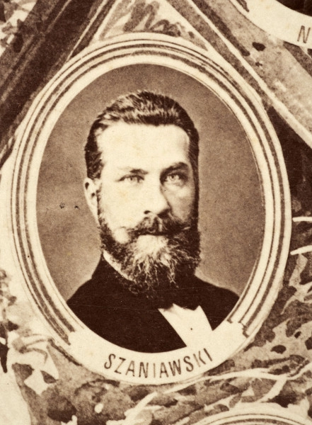 Fotografie w odcieniu sepii umieszczone na tle drzew i roślin, w centralnym miejscu postać kobiety ze sztandarem i aniołkami, wkomponowane widoki budowanej stacji, mostu kolejowego i lokomotywy. Największe zdjęcie w górnej, środkowej części bez podpisu, prawdopodobnie inż. głównej kolei nadwiślańskiej Tadeusz Chrzanowski lub jego następca Walery Titkow. Wśród podobizn pracownicy Biura Głównego Inżyniera: inż. Włodzimierz Stanisławski - pomocnik głównego inżyniera; inż. Feliks Kucharzewski -  pomocnik naczelnika biura; Feliks Kamocki - naczelnik kancelarii; Witold Lanci - naczelnik Wydz. Architektury; dr Wacław Lasocki- służba zdrowia; Władysław Radwan - sprawy zakupu gruntów; inż. Stanisław hr Scipio - projektant mostów kolejowych i jego współpracownicy: inż. Stefan Zieliński, inż. Maurycy Machalski, inż. Feliks Kucharzewski. Fotografia w passe - partout, za szkłem, oprawiona w drewnianą, profilowaną ramę.