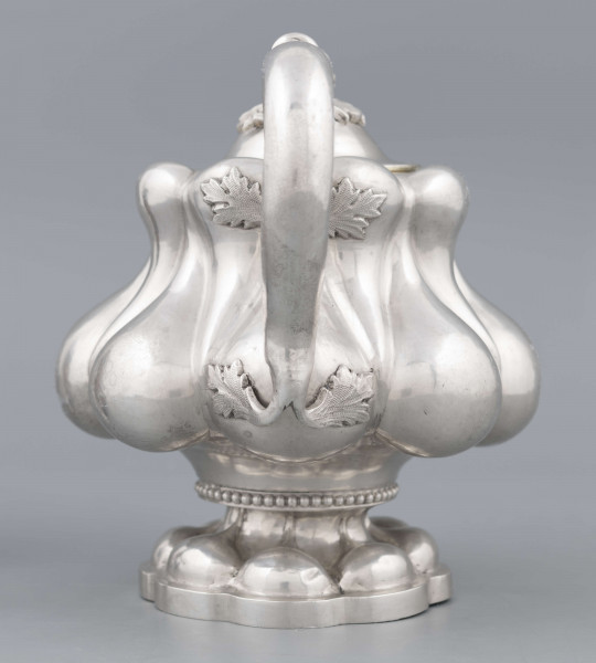 S/Mt/392/ML - Stopa ośmiolistna z ośmioma wydatnymi puklami; trzon krótki zdobiony rzedem perełek; korpus gruszkowaty pokryty dwoma rzędami pukli w formie kropel - większe na dole, mniejsze u góry; po bokach dwa ucha w formie litery 