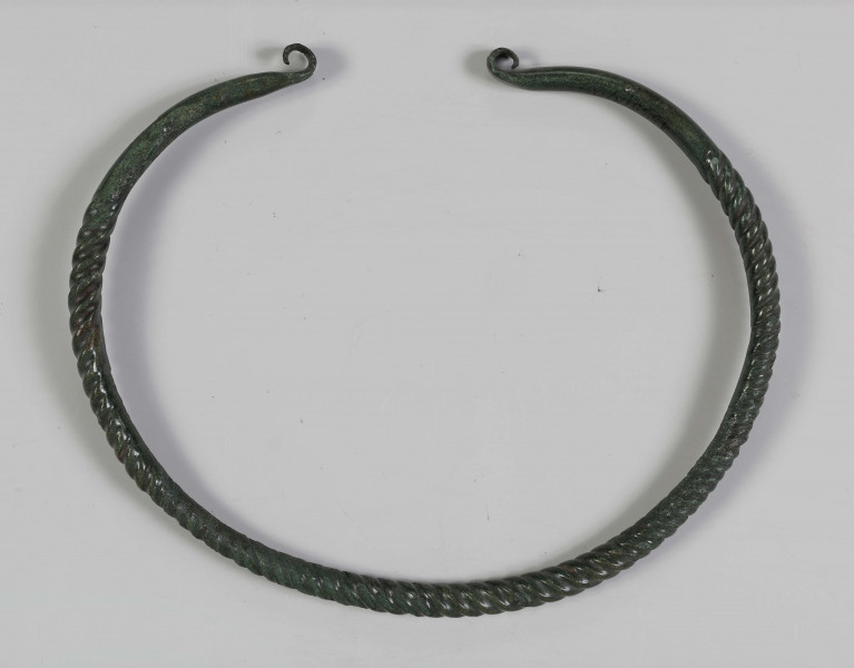 1395/A/ML/1 - Naszyjnik brązowy wykonany z brązowego pręta lanego, pokryta zieloną patyną. Całość spiralnie skręcona; końcówki rozklepane (płasko) i wywynięte na zewnątrz; końcówki naszyjnika gładkie nie skręcane 