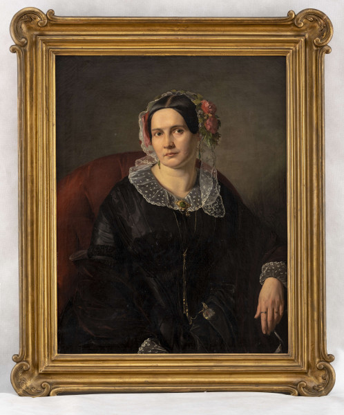 Portret młodej kobiety w ujęciu do połowy , siedzącej w bordowym fotelu w ujęciu 