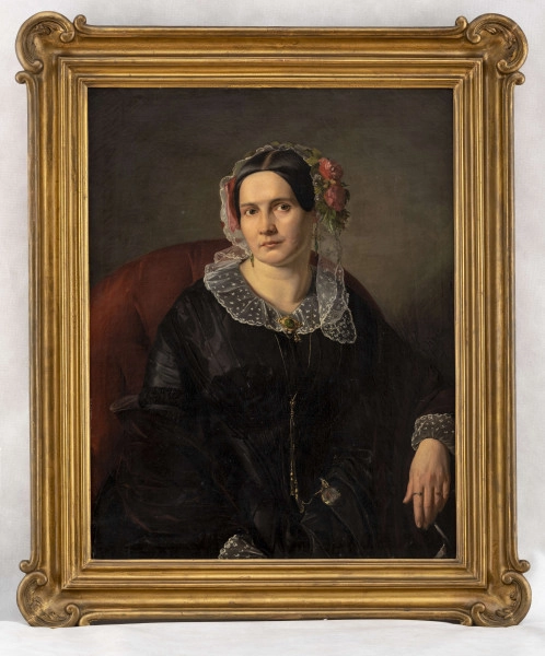 Portret młodej kobiety w ujęciu do połowy , siedzącej w bordowym fotelu w ujęciu 