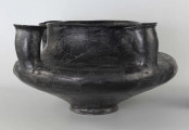 598/A/ML - naczynie kultowe (kernos) kultury pomorskiej; 
wymiary dodatkowe: 25,0 cm - średnica centralnego wylewu
opis: naczynie wazowate o czarnej, błyszczącej powierzchni, którego brzusiec został ozdobiony ornamentem złożonym z linii rytych oraz nakłuć; wokół głównego otworu posiada cztery symetrycznie rozmieszczone kielichy-rytony, które mają nieco wydęte ścianki boczne i kielichowato rozchylone na zewnątrz krawędzie otworów; rytony łączą się z głównym otworem kanalikami; 