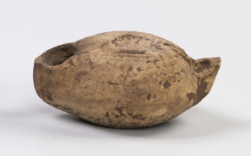 720/A/ML/3 - Uszko dtłuczone; dość duży otwór do wlewania oliwy w niewielkim zagłebieniu; dość duży owtór na płomień; lampka zdobiona w górnej partii wypukłymi granulkami układającymi się w dookolne rzędy