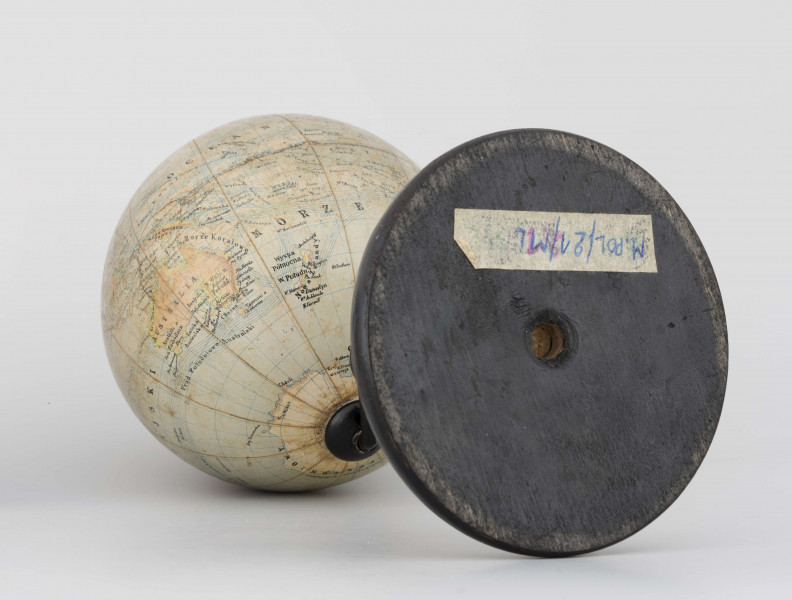 Globus fizyczno-polityczny Ziemi w skali 1:80 mln, litografia kolorowa; 12 segmentów, z polską nomenklaturą; południk zerowy biegnie przez Greenwich. Kula tekturowa, postument drewniany toczony, ramię metalowe, bez południka. Na globusie obie Ameryki, Azję i Australię otoczono czerwoną wstęgą, Afrykę - niebieską, Europa - zielono-żółtą. 