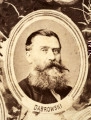 Fotografie w odcieniu sepii umieszczone na tle drzew i roślin, w centralnym miejscu postać kobiety ze sztandarem i aniołkami, wkomponowane widoki budowanej stacji, mostu kolejowego i lokomotywy. Największe zdjęcie w górnej, środkowej części bez podpisu, prawdopodobnie inż. głównej kolei nadwiślańskiej Tadeusz Chrzanowski lub jego następca Walery Titkow. Wśród podobizn pracownicy Biura Głównego Inżyniera: inż. Włodzimierz Stanisławski - pomocnik głównego inżyniera; inż. Feliks Kucharzewski -  pomocnik naczelnika biura; Feliks Kamocki - naczelnik kancelarii; Witold Lanci - naczelnik Wydz. Architektury; dr Wacław Lasocki- służba zdrowia; Władysław Radwan - sprawy zakupu gruntów; inż. Stanisław hr Scipio - projektant mostów kolejowych i jego współpracownicy: inż. Stefan Zieliński, inż. Maurycy Machalski, inż. Feliks Kucharzewski. Fotografia w passe - partout, za szkłem, oprawiona w drewnianą, profilowaną ramę.