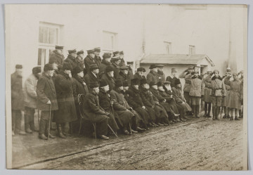 ML/H/310 - Na fotografii grupa weteranów powstania styczniowego, licząca 34 osoby. Ustawieni są w trzech rządach: pierwszy rząd siedzi na krzesłach, drugi stoi, trzeci rząd stoi na podwyższeniu. Część mężczyzn ubrana w czamaraki. Z prawej strony salutujące wojsko. Fotografia wykonana na tle budynków. Na odwrociu wykropkowane linie jak na pocztówkach oraz odręczny napis: Powstańcy z 1863 r.