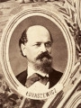 Fotografie w odcieniu sepii umieszczone na tle drzew i roślin, w centralnym miejscu postać kobiety ze sztandarem i aniołkami, wkomponowane widoki budowanej stacji, mostu kolejowego i lokomotywy. Największe zdjęcie w górnej, środkowej części bez podpisu, prawdopodobnie inż. głównej kolei nadwiślańskiej Tadeusz Chrzanowski lub jego następca Walery Titkow. Wśród podobizn pracownicy Biura Głównego Inżyniera: inż. Włodzimierz Stanisławski - pomocnik głównego inżyniera; inż. Feliks Kucharzewski -  pomocnik naczelnika biura; Feliks Kamocki - naczelnik kancelarii; Witold Lanci - naczelnik Wydz. Architektury; dr Wacław Lasocki- służba zdrowia; Władysław Radwan - sprawy zakupu gruntów; inż. Stanisław hr Scipio - projektant mostów kolejowych i jego współpracownicy: inż. Stefan Zieliński, inż. Maurycy Machalski, inż. Feliks Kucharzewski. Fotografia w passe - partout, za szkłem, oprawiona w drewnianą, profilowaną ramę.