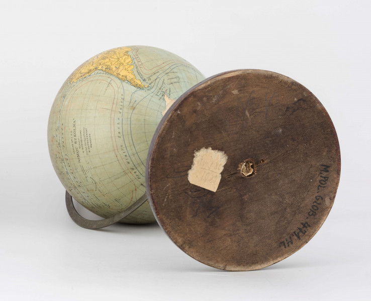 Globus fizyczny bez tytułu, roku wydania i granic politycznych. Kula tekturowa, oklejona mapą złożoną z 12 segmentów (każdy po 30 stopni) i 2 kół, postument drewniany, toczony, ozdobny, południk metalowy, 180-stopniowy, skalowany co 5 stopni, z zaznaczonymi zwrotnikami, równoleżniki zdobione, ruchomy.
Lądy - brak hipsometrii. Podstawowa sieć wodna i linia brzegowa kontynentów naznaczona na niebiesko. Powierzchnia kontynentów jest blado-żółta, poza białą Antarktydą. Na lądach zaznaczono rzeki, pustynie (sygnatura). Jeziora zakreskowano na ciemno-niebiesko. Największe góry oznaczono za pomocą metody kreskowej (w postaci 