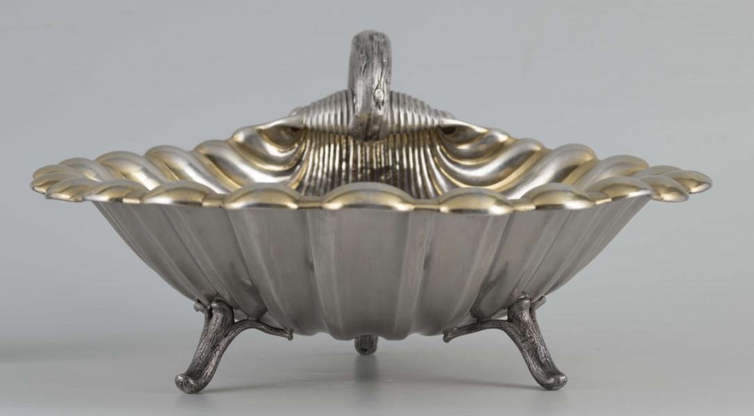 S/Mt/504/ML - Patera z uchwytem, w formie muszli przegrzebka ustawionej poziomo na  dwóch nóżkach - trzecią nóżkę tworzy zakończenie pionowo umocowanego esowatego ucha. 
Na odwrocie sygnatura segmentowa:
- znak miejski Petersburga
- znak imienny złotnika  