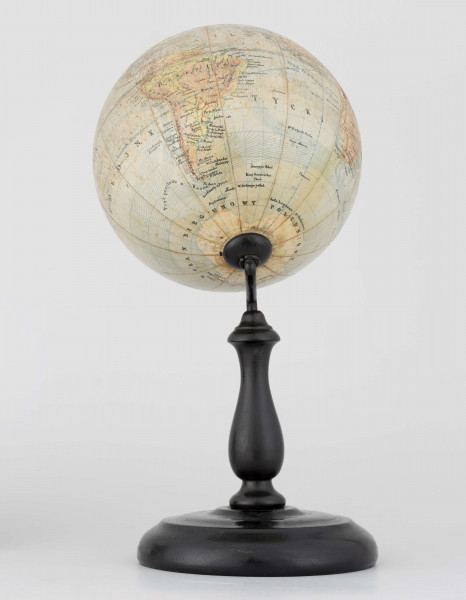 Globus fizyczno-polityczny Ziemi w skali 1:80 mln, litografia kolorowa; 12 segmentów, z polską nomenklaturą; południk zerowy biegnie przez Greenwich. Kula tekturowa, postument drewniany toczony, ramię metalowe, bez południka. Na globusie obie Ameryki, Azję i Australię otoczono czerwoną wstęgą, Afrykę - niebieską, Europa - zielono-żółtą. 