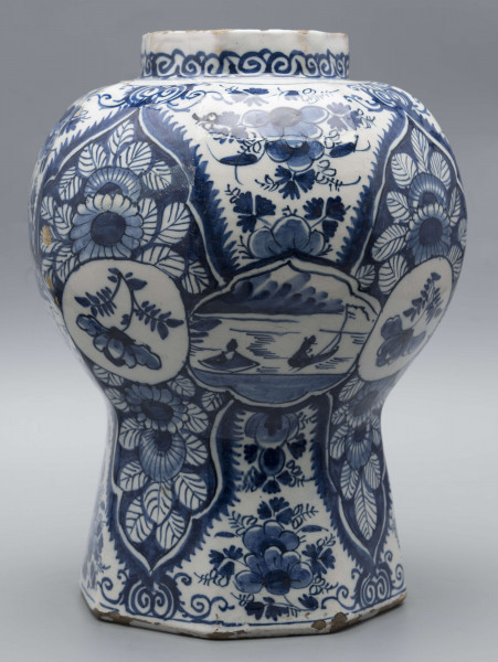 S/CS/1516/ML - Wazon balasowy z wysoka podstawą, wybrzuszonym korpusem i krótką szyją, ośmioboczny, o podziale zaznaczonym na całej wysokości. Czerep kremowy, szkliwo białe, dekoracja malowana podszkliwnie ciemnobłękitnym kobaltem. Na całej powierzchni regularnie rozmieszczony wzór lambrekinowy z motywami dużych kwiatów na błękitnym tle, przedzielony partiami białego tła z błękitnymi kwiatami. W dolnej części korpusu białe zezerwy z dekoracja naprzemienną: kwiatowa i figuralną – silnie uproszczone sylwetki ludzi w pejzażu. Na szyi fryz wolutowy.
 