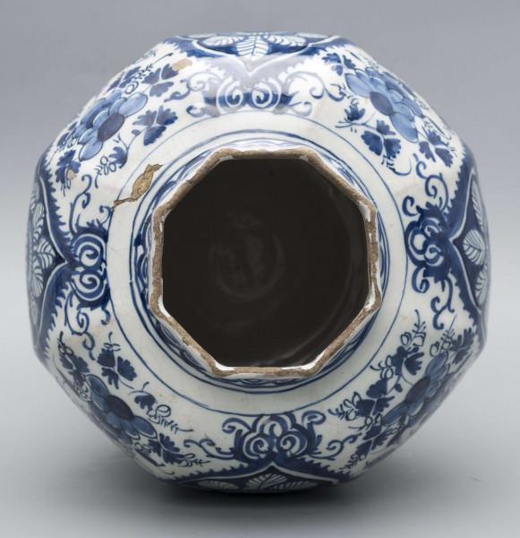 S/CS/1516/ML - Wazon balasowy z wysoka podstawą, wybrzuszonym korpusem i krótką szyją, ośmioboczny, o podziale zaznaczonym na całej wysokości. Czerep kremowy, szkliwo białe, dekoracja malowana podszkliwnie ciemnobłękitnym kobaltem. Na całej powierzchni regularnie rozmieszczony wzór lambrekinowy z motywami dużych kwiatów na błękitnym tle, przedzielony partiami białego tła z błękitnymi kwiatami. W dolnej części korpusu białe zezerwy z dekoracja naprzemienną: kwiatowa i figuralną – silnie uproszczone sylwetki ludzi w pejzażu. Na szyi fryz wolutowy.
 