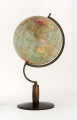 Kula tekturowa oklejona 18 segmentami mapy (po 20 stopni każdy) i 2 koła, postument drewniany toczony z metalowym ramieniem podtrzymującym kulę, południk metalowy 180-stopniowy, ruchomy, skalowany jednostronnie co 1 stopień. Model 