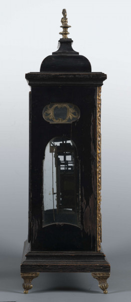 S/Mt/531/ML - Obudowa szafkowa, czworoboczna ze schodkowym zwieńczeniem, pokryta czarną politurą, oszklona z czterech stron, na czterech nóżkach z mosiądzu; w górnych narożnikach mosiężne sterczyny w formie płonących wazonów. Mechanizm chodu i bicia o napędzie sprężynowym, z wahadłem i dwoma dzwonkami; bicie godzin i kwadransów, budzik i repetier. Tarcza biało emaliowana z czarnymi cyframi arabskimi godzin i minut, w niej trzy otwory na osie sprężyn; trzy wskazówki, godzinowa i minutowa - ozdobne, sekundowa prosta. W górnej części tarczy sygnatura pisana ozdobną kursywą: M.G. / Jurkiewicz /  w Lublinie. Powyżej tarczy wycięcie z widocznym wahadełkiem kontrolnym i trzy mniejsze emaliowane tarcze: środkowa z miniaturą pejzażową, boczne z wyłączeniem chodu i bicia.