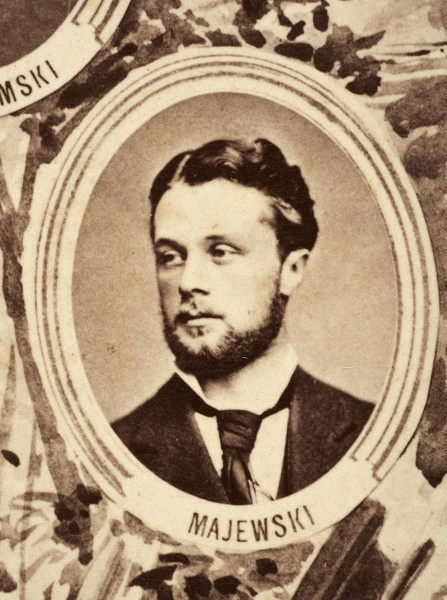 Fotografie w odcieniu sepii umieszczone na tle drzew i roślin, w centralnym miejscu postać kobiety ze sztandarem i aniołkami, wkomponowane widoki budowanej stacji, mostu kolejowego i lokomotywy. Największe zdjęcie w górnej, środkowej części bez podpisu, prawdopodobnie inż. głównej kolei nadwiślańskiej Tadeusz Chrzanowski lub jego następca Walery Titkow. Wśród podobizn pracownicy Biura Głównego Inżyniera: inż. Włodzimierz Stanisławski - pomocnik głównego inżyniera; inż. Feliks Kucharzewski -  pomocnik naczelnika biura; Feliks Kamocki - naczelnik kancelarii; Witold Lanci - naczelnik Wydz. Architektury; dr Wacław Lasocki- służba zdrowia; Władysław Radwan - sprawy zakupu gruntów; inż. Stanisław hr Scipio - projektant mostów kolejowych i jego współpracownicy: inż. Stefan Zieliński, inż. Maurycy Machalski, inż. Feliks Kucharzewski. Fotografia w passe - partout, za szkłem, oprawiona w drewnianą, profilowaną ramę.