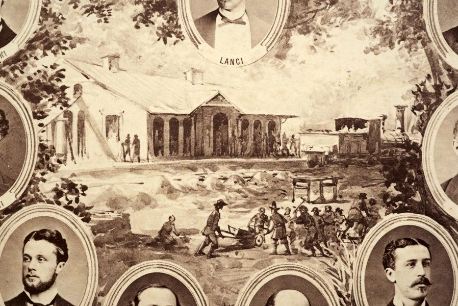 Fotografie w odcieniu sepii umieszczone na tle drzew i roślin, w centralnym miejscu postać kobiety ze sztandarem i aniołkami, wkomponowane widoki budowanej stacji, mostu kolejowego i lokomotywy. Największe zdjęcie w górnej, środkowej części bez podpisu, prawdopodobnie inż. głównej kolei nadwiślańskiej Tadeusz Chrzanowski lub jego następca Walery Titkow. Wśród podobizn pracownicy Biura Głównego Inżyniera: inż. Włodzimierz Stanisławski - pomocnik głównego inżyniera; inż. Feliks Kucharzewski -  pomocnik naczelnika biura; Feliks Kamocki - naczelnik kancelarii; Witold Lanci - naczelnik Wydz. Architektury; dr Wacław Lasocki- służba zdrowia; Władysław Radwan - sprawy zakupu gruntów; inż. Stanisław hr Scipio - projektant mostów kolejowych i jego współpracownicy: inż. Stefan Zieliński, inż. Maurycy Machalski, inż. Feliks Kucharzewski. Fotografia w passe - partout, za szkłem, oprawiona w drewnianą, profilowaną ramę.