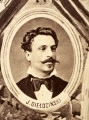 Fotografie w odcieniu sepii umieszczone na tle drzew i roślin, w centralnym miejscu postać kobiety ze sztandarem i aniołkami, wkomponowane widoki budowanej stacji, mostu kolejowego i lokomotywy. Największe zdjęcie w górnej, środkowej części bez podpisu, prawdopodobnie inż. głównej kolei nadwiślańskiej Tadeusz Chrzanowski lub jego następca Walery Titkow. Wśród podobizn pracownicy Biura Głównego Inżyniera: inż. Włodzimierz Stanisławski - pomocnik głównego inżyniera; inż. Feliks Kucharzewski -  pomocnik naczelnika biura; Feliks Kamocki - naczelnik kancelarii; Witold Lanci - naczelnik Wydz. Architektury; dr Wacław Lasocki- służba zdrowia; Władysław Radwan - sprawy zakupu gruntów; inż. Stanisław hr Scipio - projektant mostów kolejowych i jego współpracownicy: inż. Stefan Zieliński, inż. Maurycy Machalski, inż. Feliks Kucharzewski. Fotografia w passe - partout, za szkłem, oprawiona w drewnianą, profilowaną ramę.