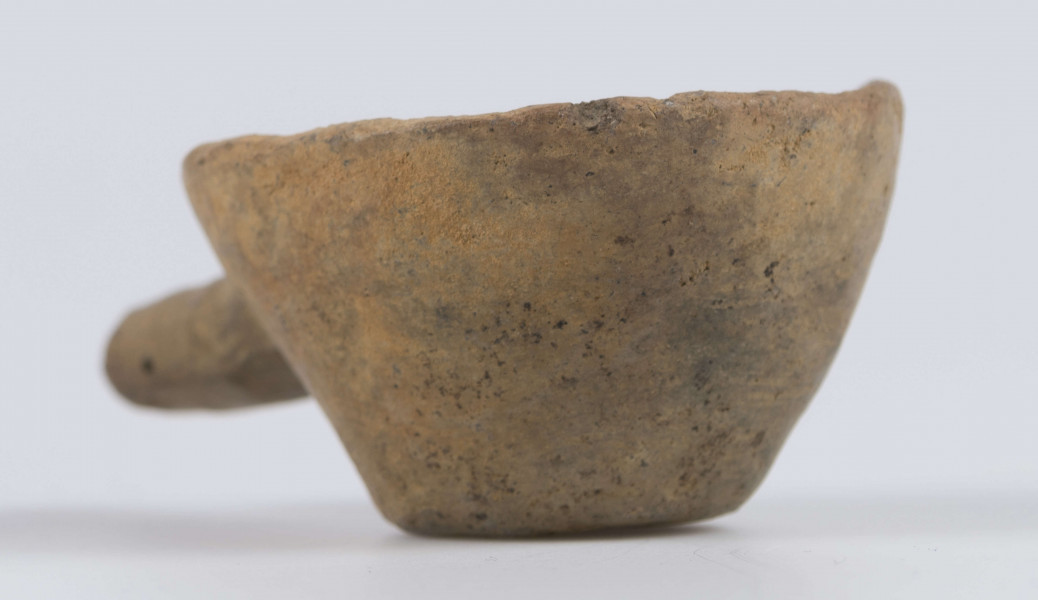 1702/A/ML - dno płaskie, ścianki proste, wylew zawinięty do wewnątrz; krawędź zaokrąglona; pod krawędzią umieszczono trzymadełko prostopadłe do ścianki, o przekroju owalnym, ułamane